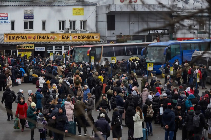 Đám đông đứng chờ tại một trạm xe buýt khi cố gắng rời khỏi thủ đô Kiev. Ảnh: Reuters.