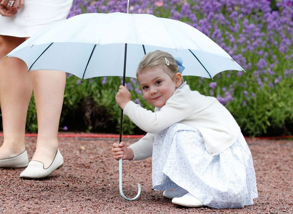 Công chúa Estelle tinh nghịch ngồi dưới một chiếc ô để chụp ảnh ngày 14/7/2015. Ảnh: IT.