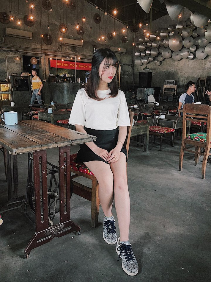 Áo phông trắng và váy đen mix với giày thể thao giúp cô nàng trông vừa cá tính vừa dễ thương.