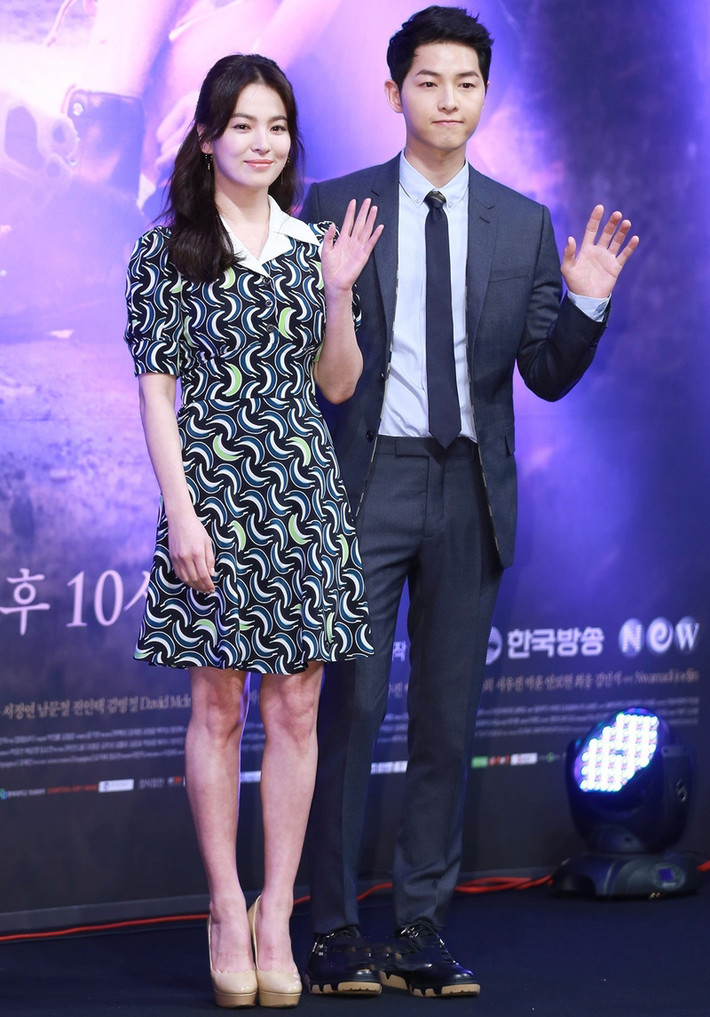 Vì chiều cao “khiêm tốn”, Song Hye Kyo luôn mang giày cao gót dáng trơn, phối với đầm chít eo có họa tiết độc đáo. Bộ đầm “nhuộm” sắc xanh trầm của cô khá hợp tông với trang phục của Song Joong Ki.