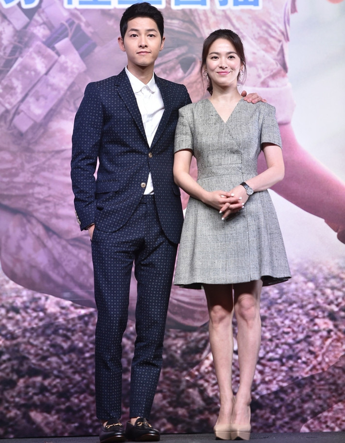 Song Joong Ki bảnh bao với vest đen họa tiết nhỏ, còn bạn gái anh đơn giản, thanh lịch trong bộ váy xòe xẻ cổ chữ V.