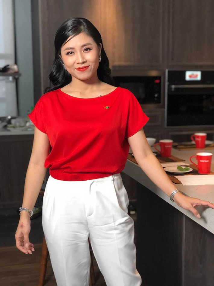 Khi đi làm, cô chọn áo sơ mi đỏ và quần trắng nổi bật.