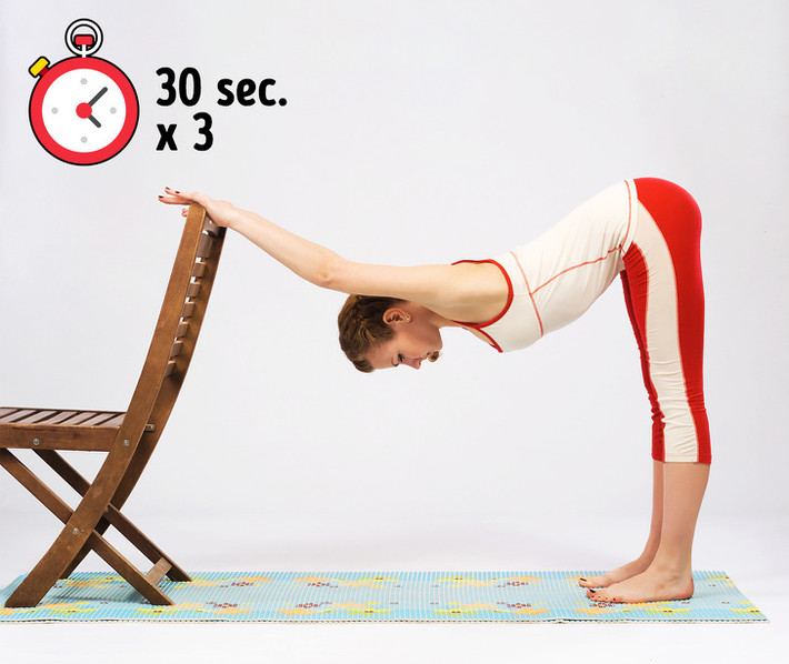 Cúi gập với ghế: Đứng thẳng và tay đặt lên ghế hoặc tường. Uốn cong phần trên cơ thể để căng cơ lưng và đùi. Giữ thân dưới thẳng. Giữ vị trí này 30 giây và lặp lại hai lần hoặc thậm chí 3 lần. Ảnh: BS.