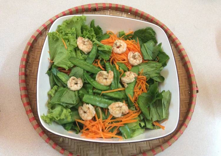 Salad cải bó xôi trộn tôm: Các nguyên liệu phải được rửa sạch và ngâm nước muối loãng. Đậu và cà rốt dội qua nước sôi, tôm bóc vỏ, ướp với muối và áp chảo cho chín. Cho tất cải bỏ xôi xắt khúc, tôm, đậu và cà rốt vào tô lớn rồi thêm dầu mè, nước tương vào đảo nhẹ tay, dứa cắt lát mỏng trộn đều. Vậy là bạn đã có món salad ngon miệng. Ảnh: Cookpad.