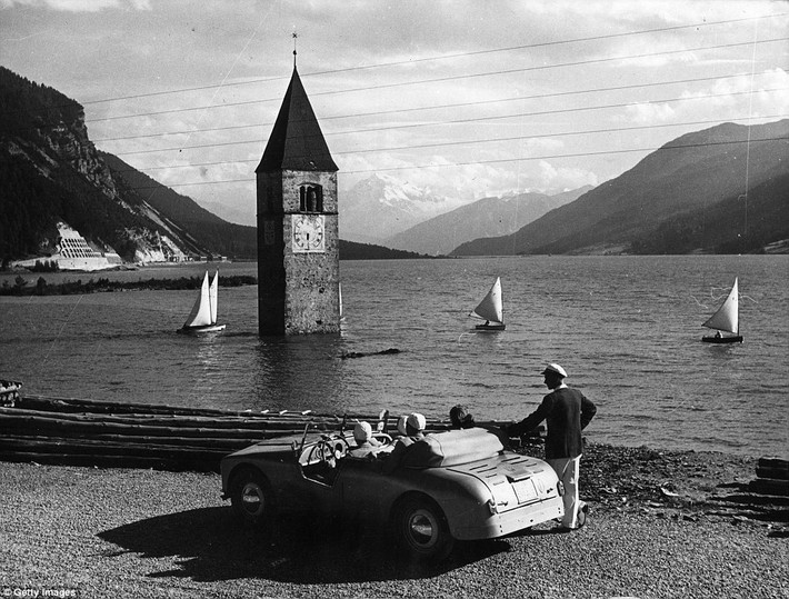 Cảnh đẹp tại hồ Reschen, miền Nam Tyrol, Italy. Làng Graun bị hồ nước này nhấn chìm chỉ còn nhìn thấy tháp chuông nhà thờ nổi trên mặt nước. Đây cũng là nơi diễn ra Giải vô địch cuộc thi đua thuyền năm 1953.