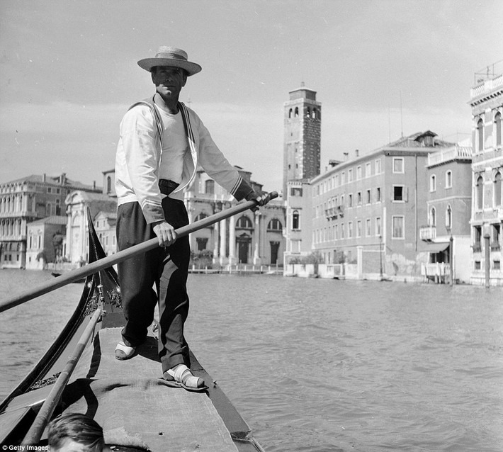 Người chèo thuyền chở khách ngắm cảnh đẹp Venice qua các kênh. Du khách có cơ hội ngắm cảnh thành phố xinh đẹp này bằng cách thuê thuyền đi dạo trên kênh. Ảnh chụp tại Italy vào khoảng năm 1950.