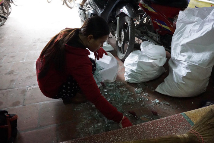 Người dân thu gom lại những mảnh kính vỡ.