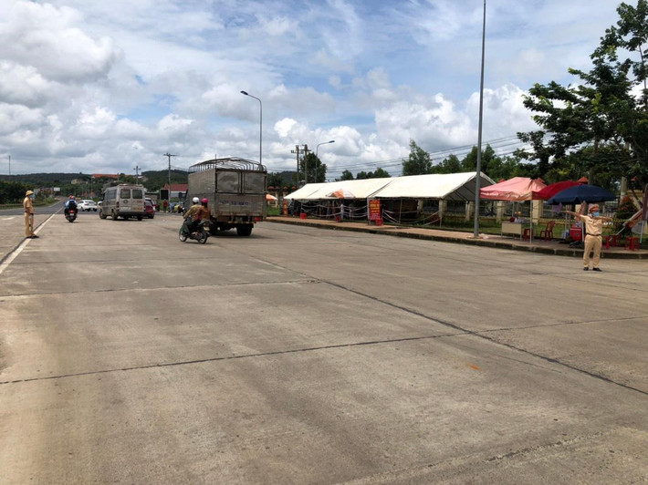 Để tránh việc người dân tụ tập đông tại chốt phòng dịch gia tăng nguy cơ lây nhiễm chéo, Phòng CSGT Đắk Nông đã cử lực lượng và phương tiện dẫn đường cho những người này đến địa phận tỉnh Đắk Lắk. Trong ảnh: Lực lượng CSGT phân luồng xe tại chốt kiểm dịch Cai Chanh.