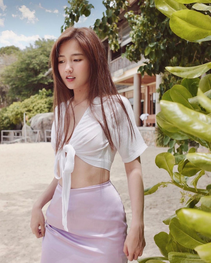 Kiều Trinh diện áo kiểu buộc dây dáng croptop với váy lụa duyên dáng và sexy.
