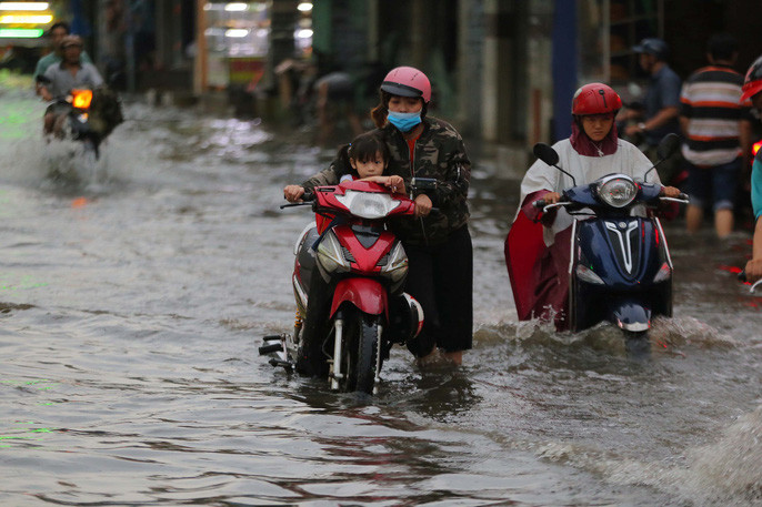 Nhiều tuyến đường không kịp thoát nước nên bị ngập nặng. Người đi đường phải dắt bộ khi xe chết máy trên đường Lê Quang Sung, quận 6, TP HCM.
