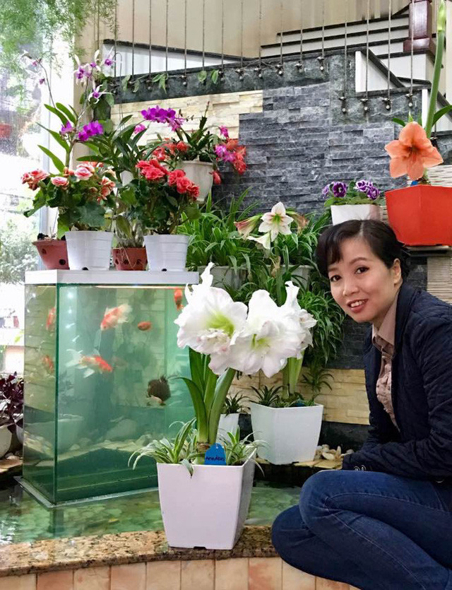 Mẹ Bích Phương bên những chậu hoa rực rỡ do chính mình chăm sóc.