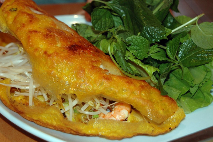 Bánh Xèo là đặc sản ở miền Trung Việt Nam. Thỉnh thoảng, món ăn này được gọi là “bánh crepe” Việt kiểu miền Trung. Bánh Xèo là sự pha trộn hài hòa giữa lớp bột gạo được chiên vàng giòn quấn quanh rau tươi, tôm, giá đỗ, thịt. Món ăn này sẽ tuyệt vời hơn khi chấm kèm nước mắm đậu phộng.
