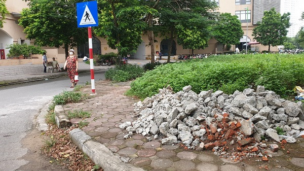 Phế thải xây dựng đổ bừa bãi trên hè.