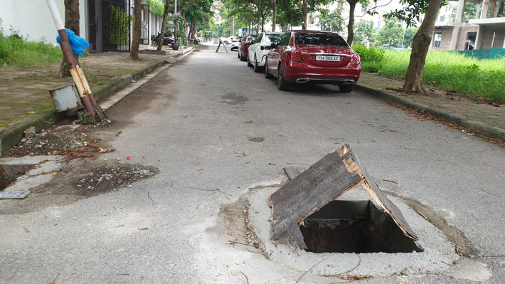 Để cảnh báo, người dân đành xếp tấm gỗ lên trên nắp cống báo hiệu cho người khác chú ý, tránh sa vào hố cống không có nắp khi qua lại trên đường.