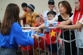 Tình nguyện viên phát nước miễn phí cho người dân xem sơ duyệt diễu binh