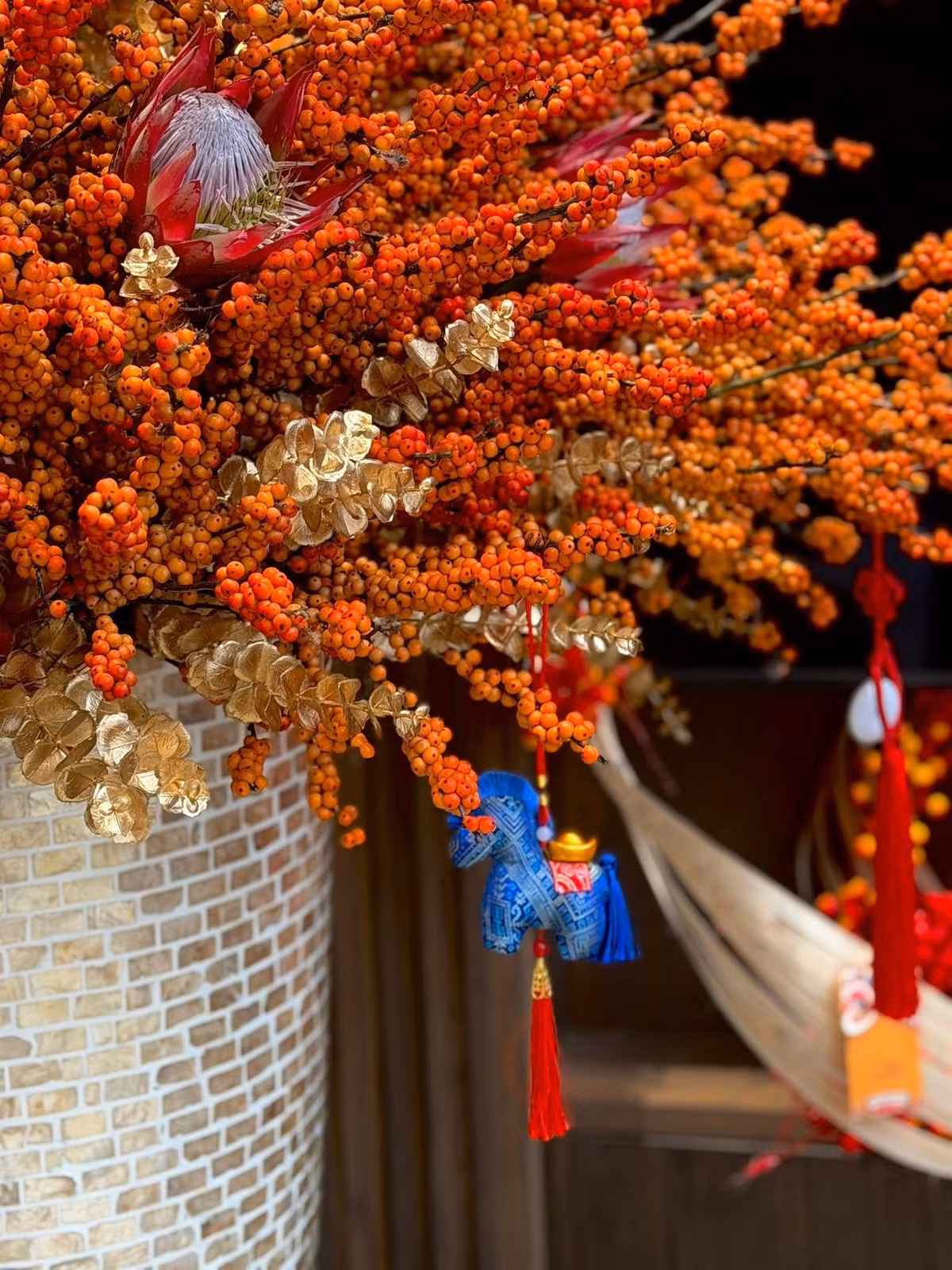 Sự kết hợp giữa những cành đào đông đỏ rực và những cành lá phủ ánh vàng kim tạo nên tổng thể quý phái. Ảnh: FB Dam Thu Trang