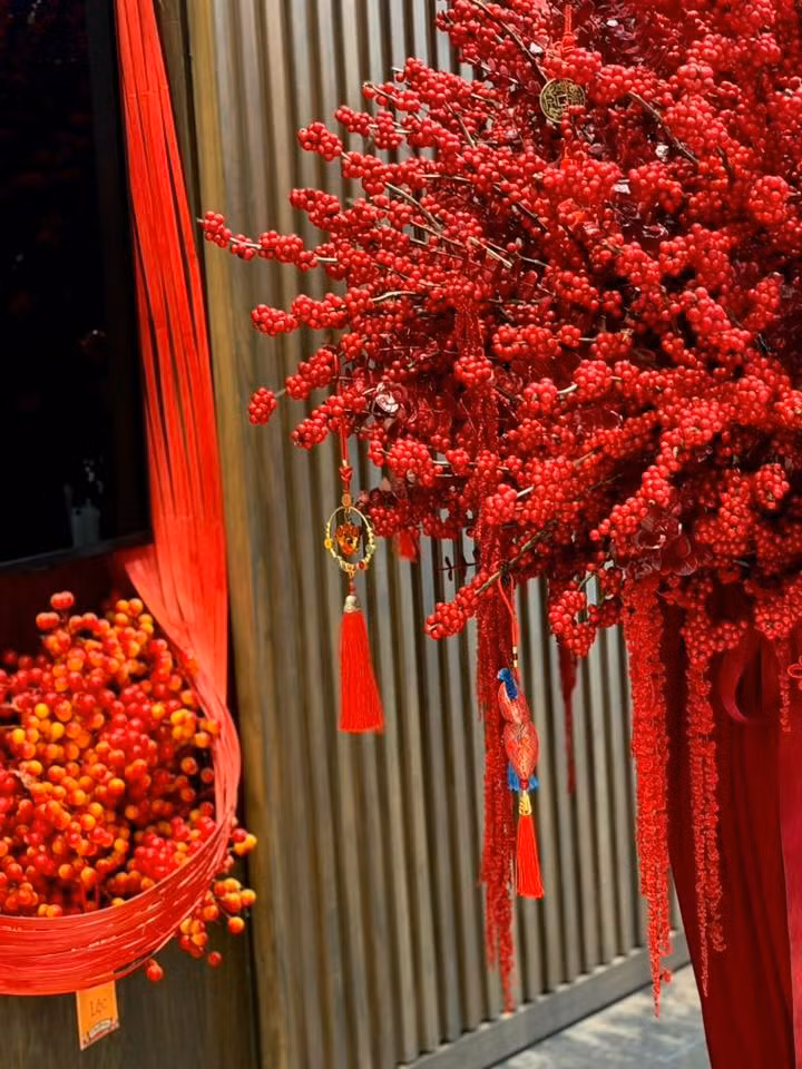 Màu đỏ rực rỡ tượng trưng cho sự may mắn và tài lộc, được kết hợp khéo léo với những chiếc khánh treo, đồng xu cổ và tua rua đỏ, tạo cảm giác ấm cúng. Ảnh: FB Dam Thu Trang