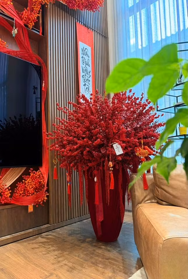 Ánh sáng từ cửa sổ lớn tràn vào giúp tôn lên sắc đỏ thắm của bình đào đông đỏ và vẻ đẹp hiện đại của căn phòng. Ảnh: FB Dam Thu Trang