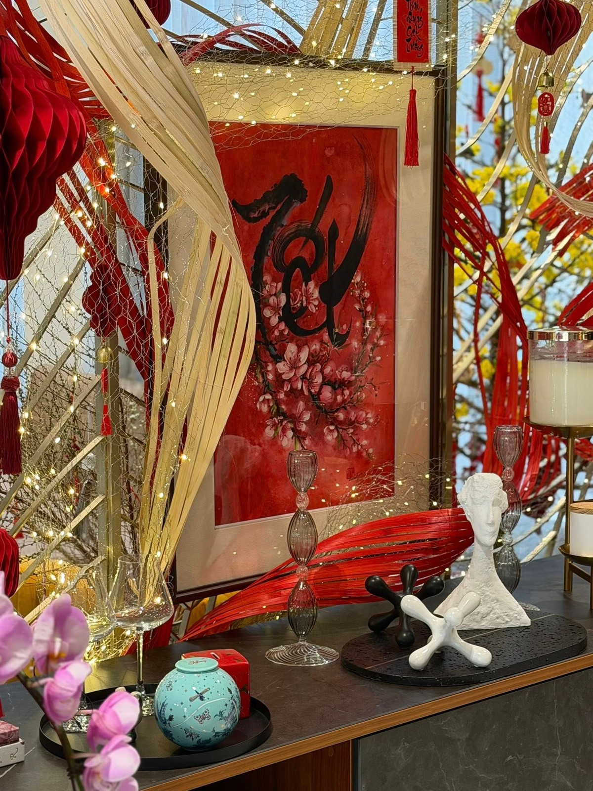 Không gian thêm phần tinh tế với những vật phẩm decor như tượng đá trắng, nến thơm, ly rượu vang và những chiếc đèn lồng giấy xếp. Ảnh: FB Dam Thu Trang