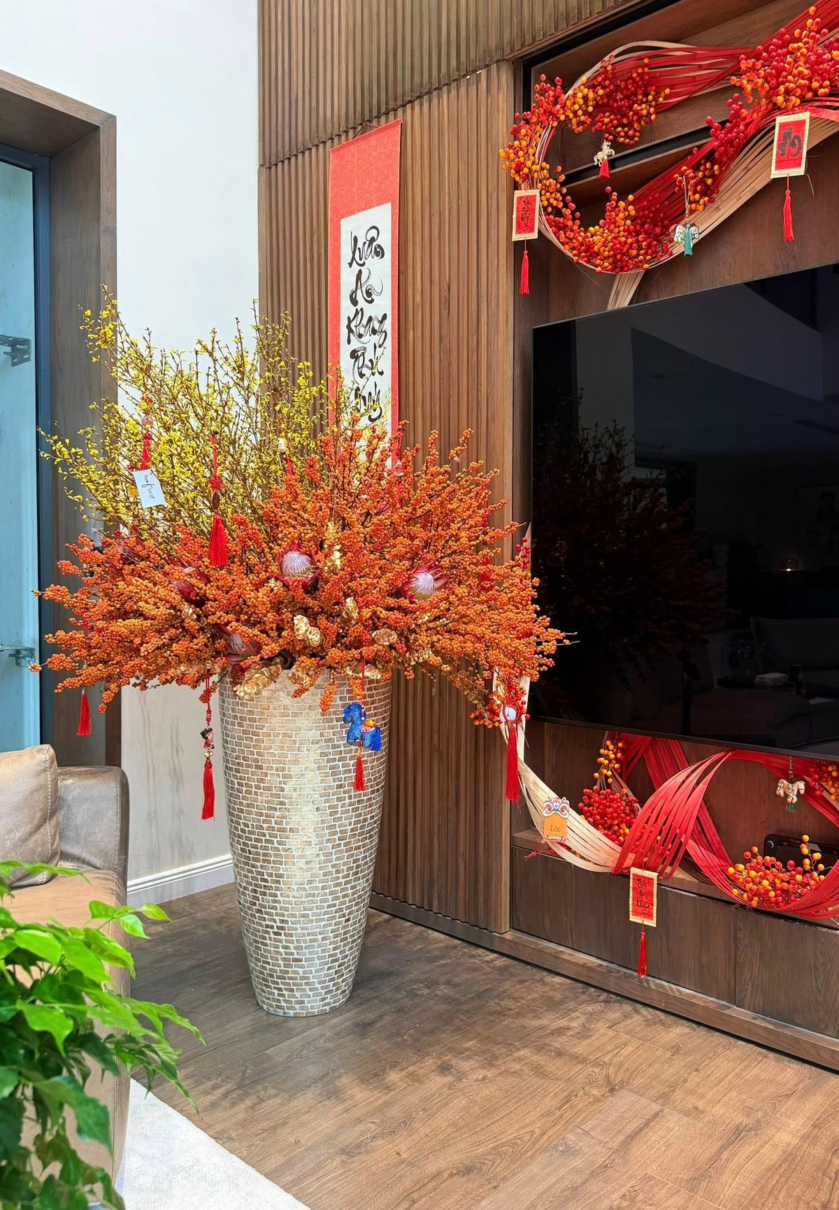 Sự đan xen giữa sắc vàng tươi của hoa và sắc cam đỏ của các loại quả tạo nên "bữa tiệc" màu sắc đầy sức sống, hài hòa với nội thất gỗ trầm mặc của biệt thự. Ảnh: FB Dam Thu Trang