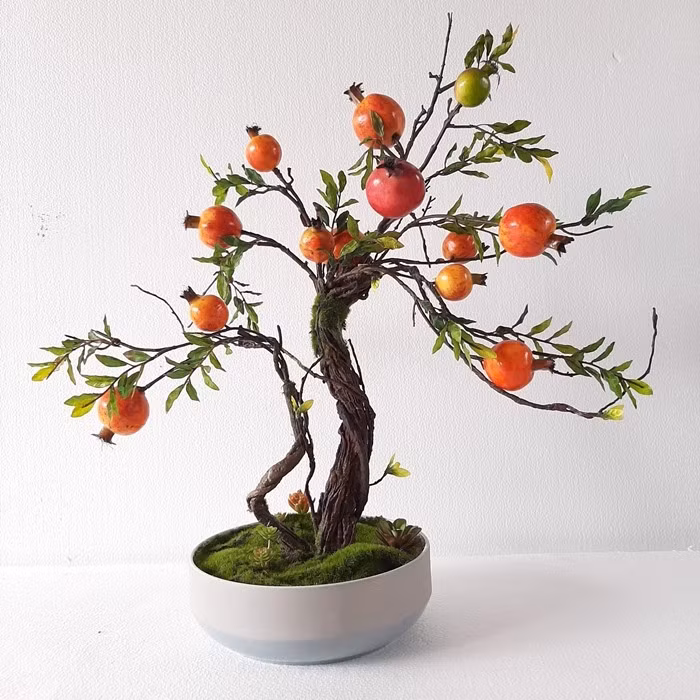 Với hoa đỏ, quả tròn đầy, ruột nhiều hạt, cây lựu mang ý nghĩa gia đình sung túc, con cháu đề huề. Ảnh: Lan Decor