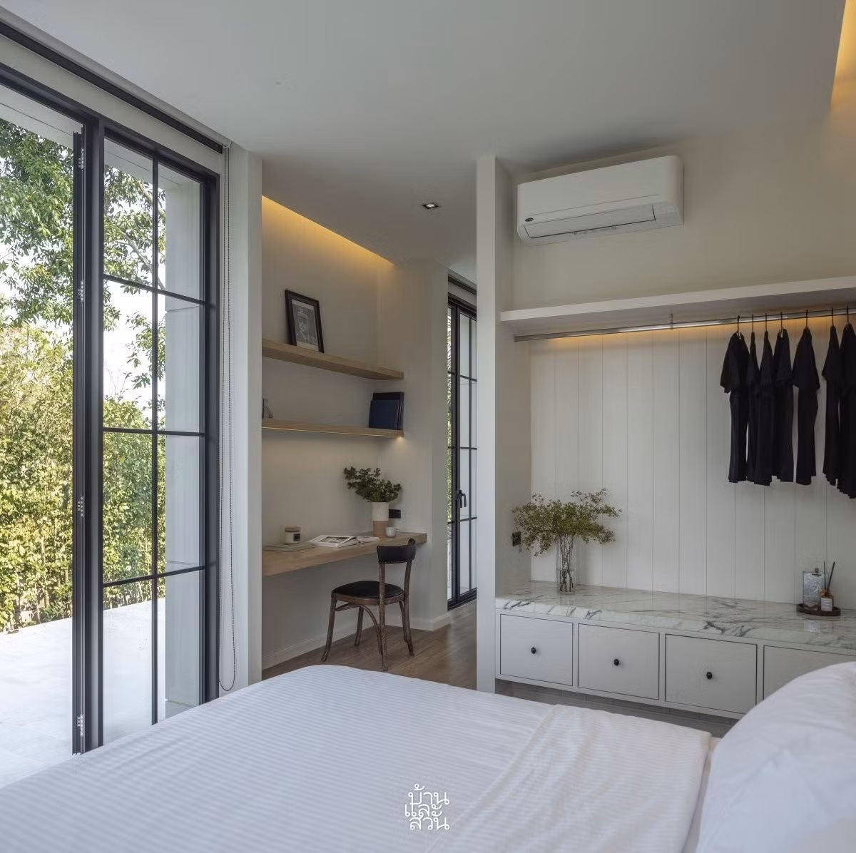 Phòng ngủ chính mở ra không gian xanh, đặt thêm một chiếc bàn góc ở hành lang. Ảnh: Baanlaesuan