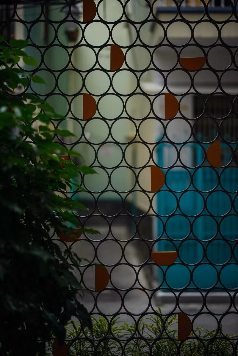 Các ô sắt tròn và bán nguyệt đan xen giúp ngôi nhà 26m2 trong hẻm không bí bách. Ảnh: Quang Trần