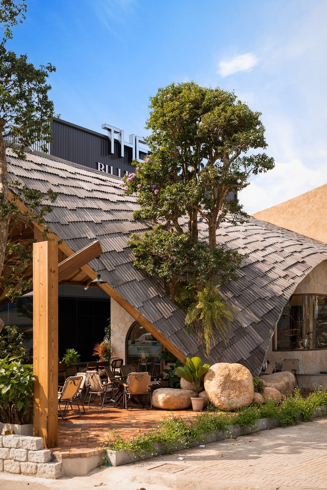 Mái nhà được ốp bằng các tấm kim loại nhỏ với nhiều màu sắc, hình dạng và kích thước khác nhau, xếp lớp theo hình vảy cá - một chi tiết bắt mắt trở thành yếu tố thị giác đặc trưng của quán cà phê. Ảnh: Minq Bui