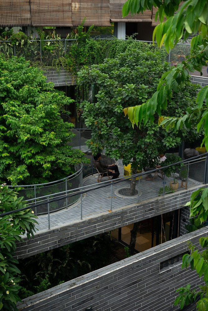 Phía trên khu vườn là một hiên nhà rộng bao quanh. Nơi đây giống như một "sân chơi" rộng lớn, không gian liền mạch từ bên trong ra hiên nhà, tạo thành một vòng tròn liên tục bên dưới những tán cây. Ảnh: Quangdam