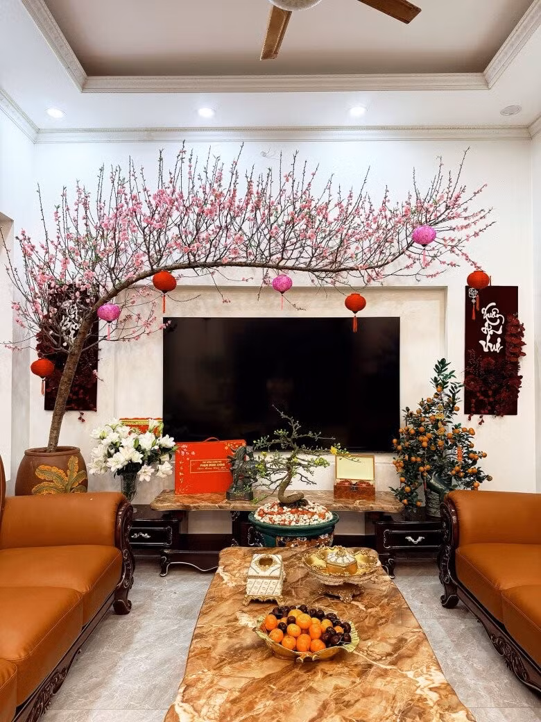 Dịp Tết vừa qua, Hòa Minzy hé lộ một góc nhà trang trí đậm chất truyền thống với cành đào dáng huyền mềm mại, điểm xuyết đèn lồng đỏ rực rỡ. Ảnh: FBNV