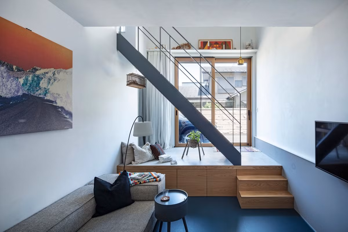 Lối vào nhà là cửa trượt kính khung gỗ lớn, phía sau là cầu thang mở dẫn lên tầng trên. Ảnh: Kenta Hasegawa