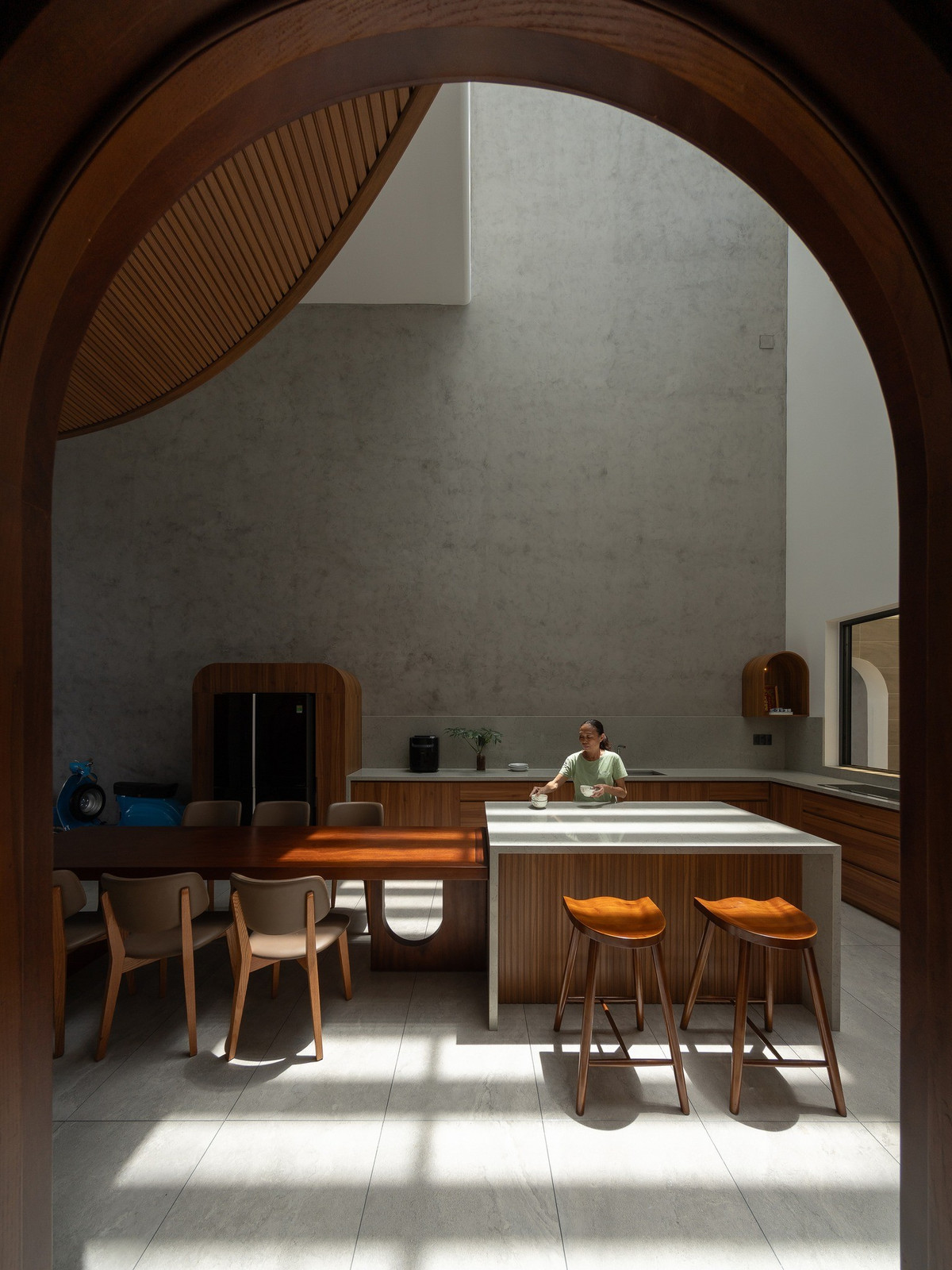 Bếp và bàn ăn là trung tâm sinh hoạt của gia đình, được thiết kế thông tầng xuyên suốt lên mái giúp căn nhà luôn thoáng đãng. Ảnh: Quang Dam