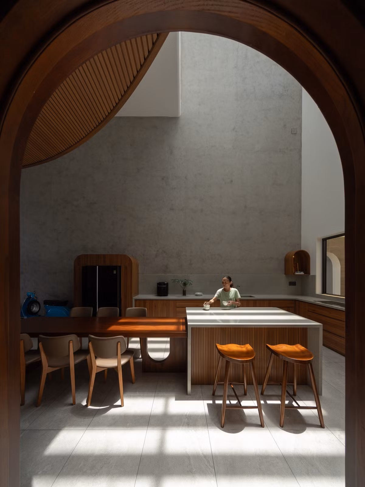 Bếp và bàn ăn là trung tâm sinh hoạt của gia đình, được thiết kế thông tầng xuyên suốt lên mái giúp căn nhà luôn thoáng đãng. Ảnh: Quang Dam