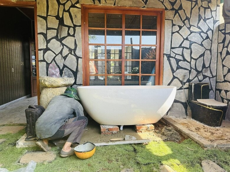 Phòng tắm thiết kế mở, tường ốp đá tự nhiên và bồn tắm lớn. Ảnh: FBNV