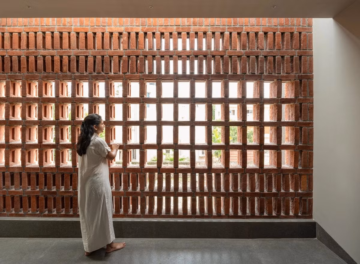 Mặt tiền hướng Tây được xử lý bằng hệ gạch thông gió, tạo lớp vỏ kép giúp lọc ánh sáng, đồng thời mang đến hiệu ứng đổ bóng và giảm bức xạ nhiệt. Ảnh: Archdaily