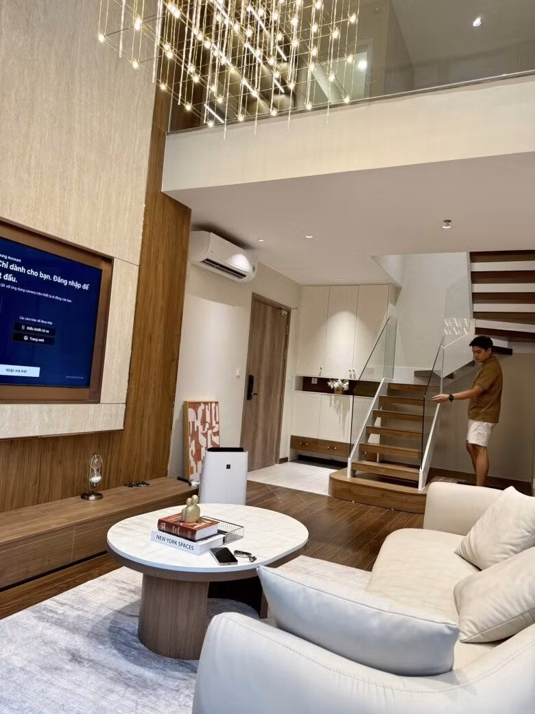 Cầu thang tay vịn với bậc gỗ nổi bật trên nền trắng. Ảnh: FBNV