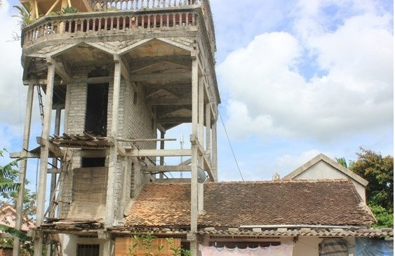 Dù xây cao chót vót nhưng nhà không có móng chắc chắn mà được gắn hờ vào bờ tường của ngôi nhà cấp 4 cũ được xây từ vữa vôi cách đây hàng chục năm. Ảnh: GiadinhVietNam