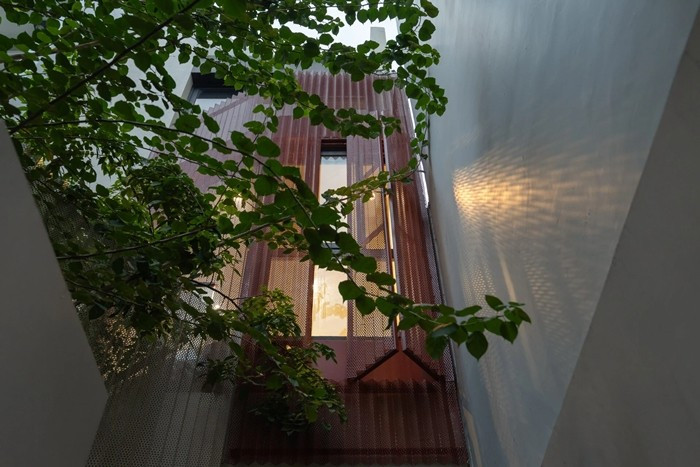 Mặt tiền phủ lưới thép giúp chắn nhìn trực diện từ tuyến đường nhỏ và giảm bức xạ nắng cho sân trước. Ảnh: Quang Dam