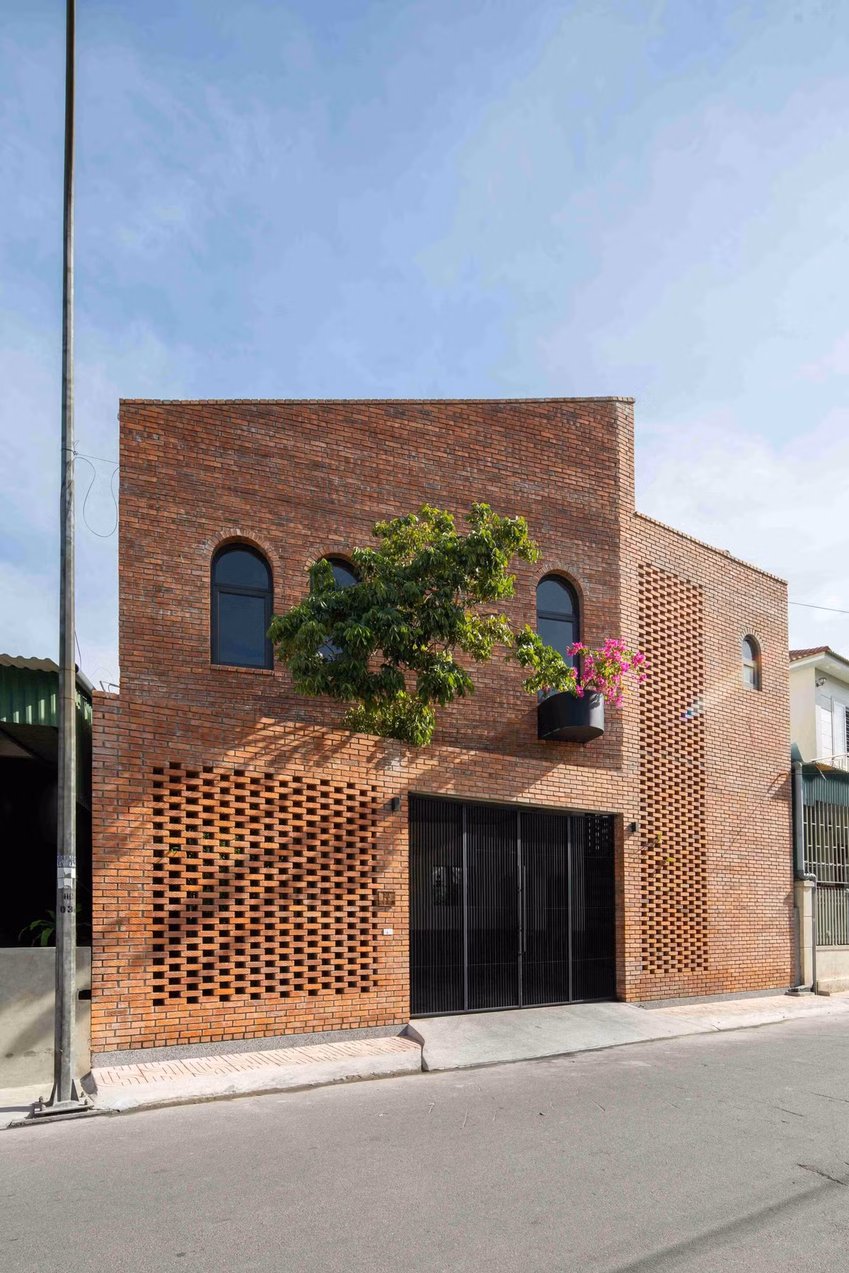 Giữa khu dân cư đông đúc, ngôi nhà nổi bật với mặt tiền gạch nung mộc mạc, gần gũi. Ảnh: Hoang Le