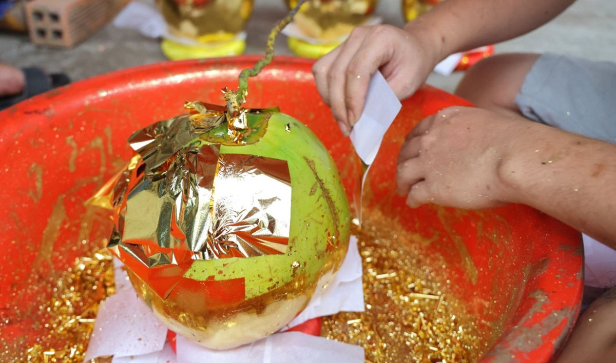 Trung bình mỗi trái dừa cần tới 30–40 lá vàng 24K, tất cả đều làm thủ công. Ảnh: Báo tin tức