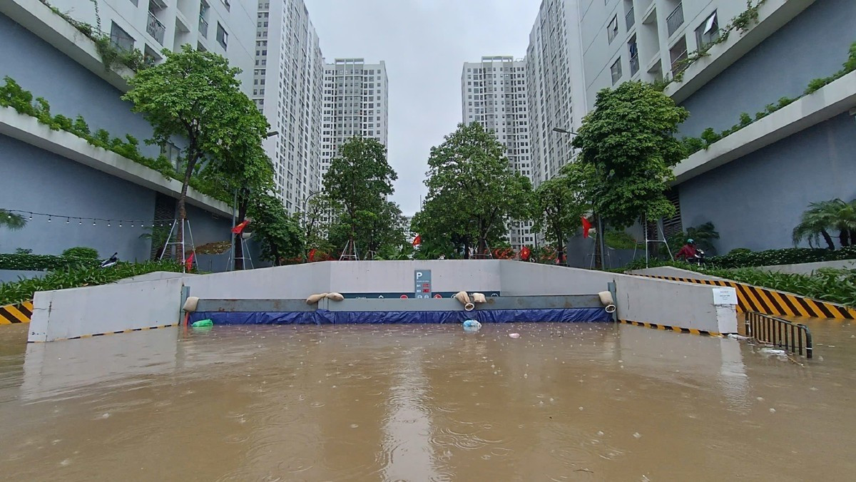 Cư dân cùng ban quản lý tòa nhà dựng đập, rào chắn để ngăn nước tràn vào hầm xe. Ảnh: Đ.C/VNN.