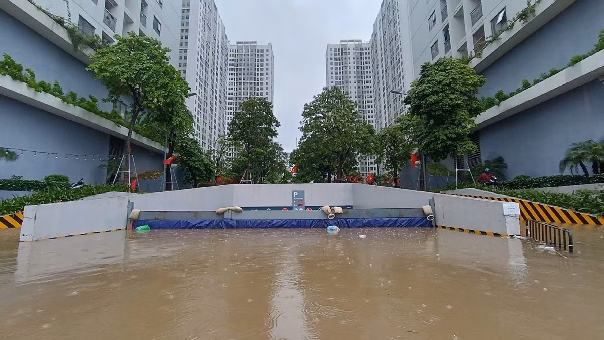 Cư dân cùng ban quản lý tòa nhà dựng đập, rào chắn để ngăn nước tràn vào hầm xe. Ảnh: Đ.C/VNN.