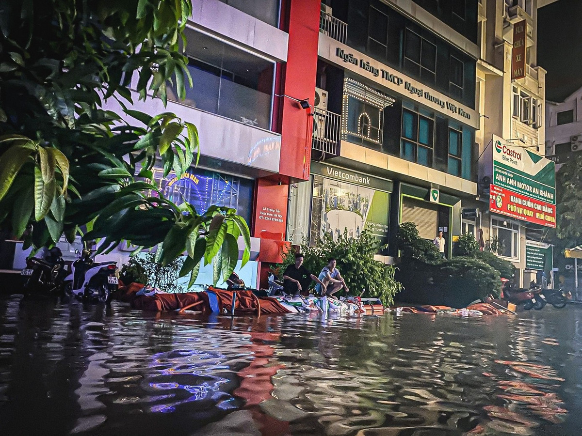 Nhiều hộ tranh thủ dùng máy phát điện để bơm nước ra khỏi hầm. Ảnh: Tiền phong