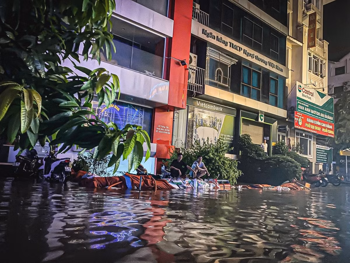 Nhiều hộ tranh thủ dùng máy phát điện để bơm nước ra khỏi hầm. Ảnh: Tiền phong