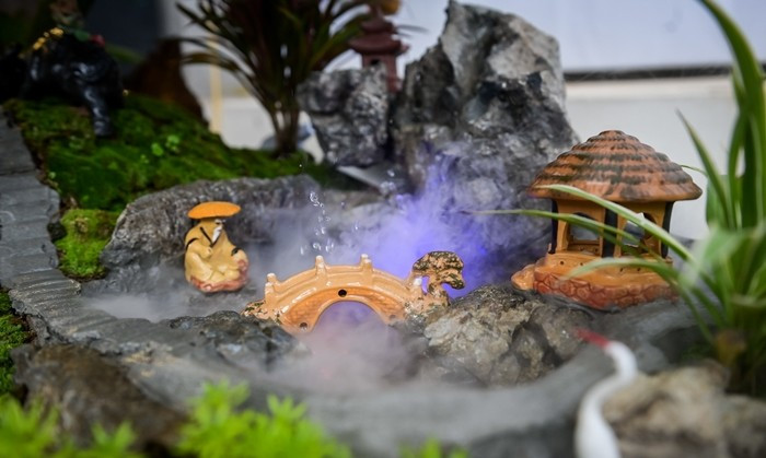 Để kịp tiến độ, một số nhà vườn thuê thêm nhiều lao động làm việc thường xuyên, mỗi người đảm nhận một công đoạn: người chuyên làm các chi tiết tiểu cảnh, người chuyên lên chậu. Ảnh: Vietnamnet