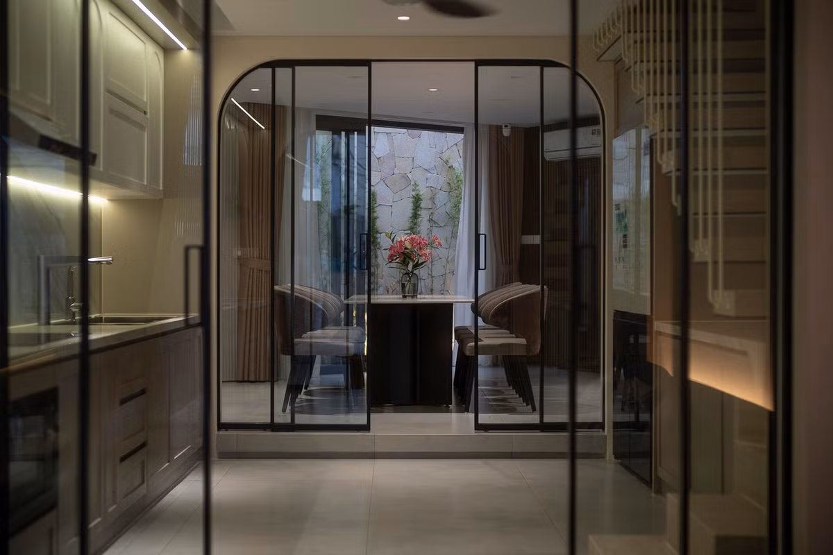 Cửa kính khung vòm kết nối không gian từ phòng khách đến bàn ăn, tạo mở rộng thị giác trong nhà ống. Ảnh: Quang Trần