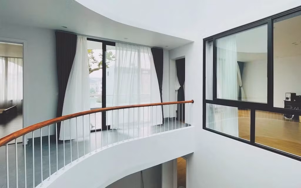 Cầu thang uốn lượn là điểm nhấn mềm mại, tạo sự kết nối giữa các tầng. Ảnh: NguyenhieuARC