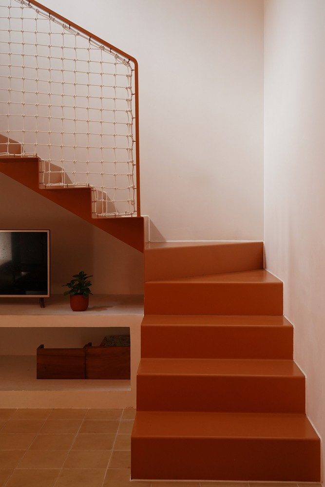 Cầu thang thép thanh mảnh, hoàn thiện với lan can dây thừng đan thủ công. Ảnh: Live out studio