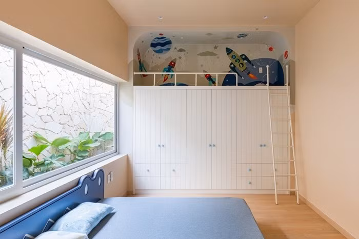 Phòng ngủ cho bé nổi bật với giường thiết kế riêng, tủ cao kịch trần tích hợp gác xép, tạo không gian vừa ngủ vừa chơi. Ảnh: Da Vàng studio