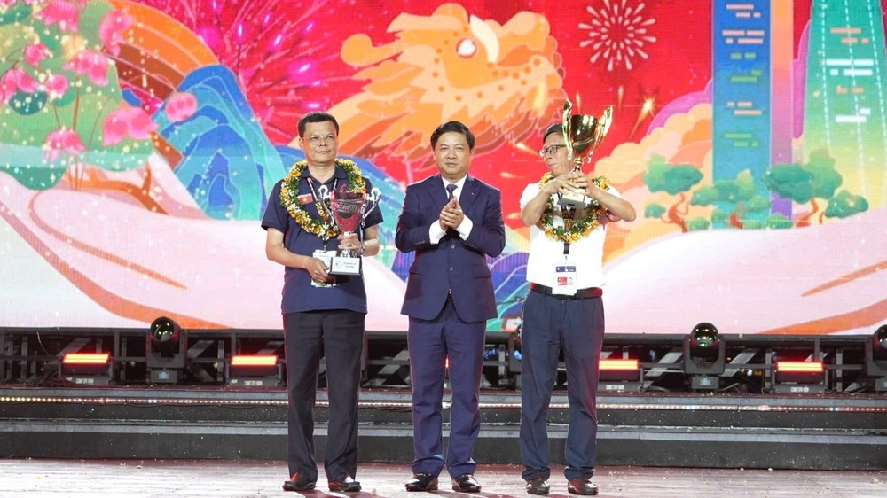 Đại diện đội pháo hoa đến từ Trung Quốc (bên phải) nhận chức vô địch, cùng đại diện đội Á quân - Z121 của Bộ Quốc phòng Việt Nam. Ảnh: TẤN VIỆT